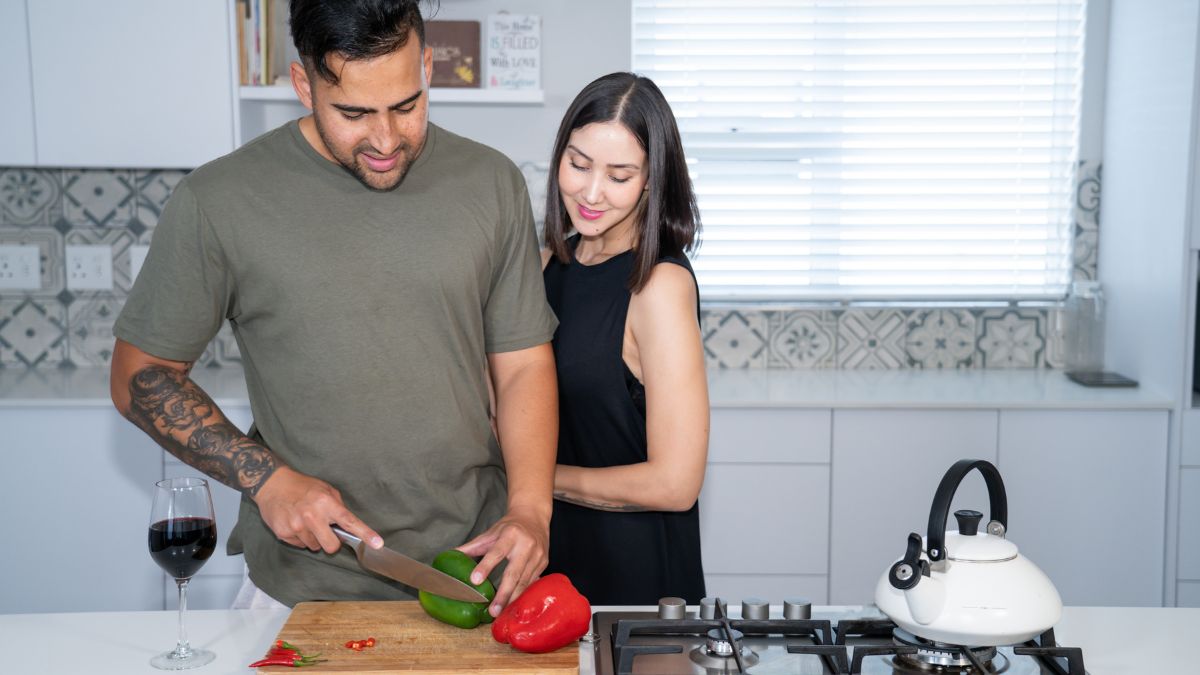 man helping his girlfriend in kitchen